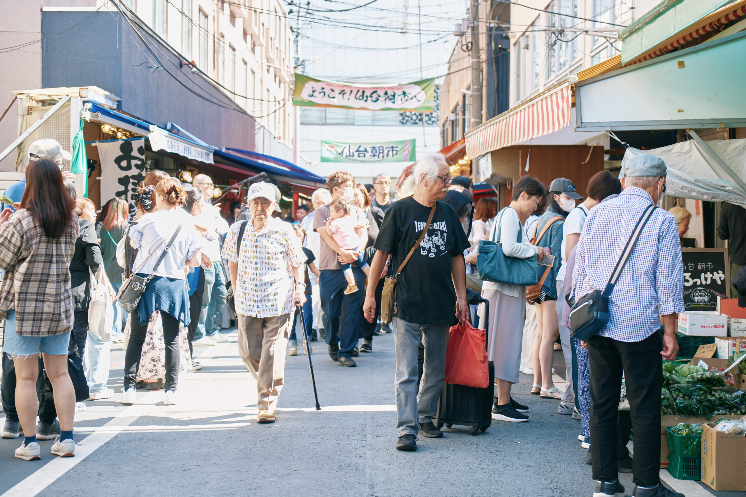 両サイドの店頭を眺めながら、お買い得品を見極める買い物上手の尾﨑さん。「ここでは煮干しの頭、ここではかまぼこ…」と、店ごとにお気に入りも。